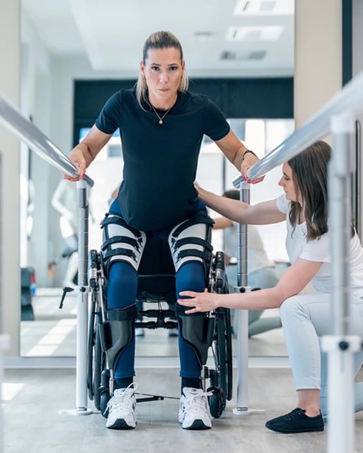 A patient walking with the Ottobock C-Brace and therapist support.