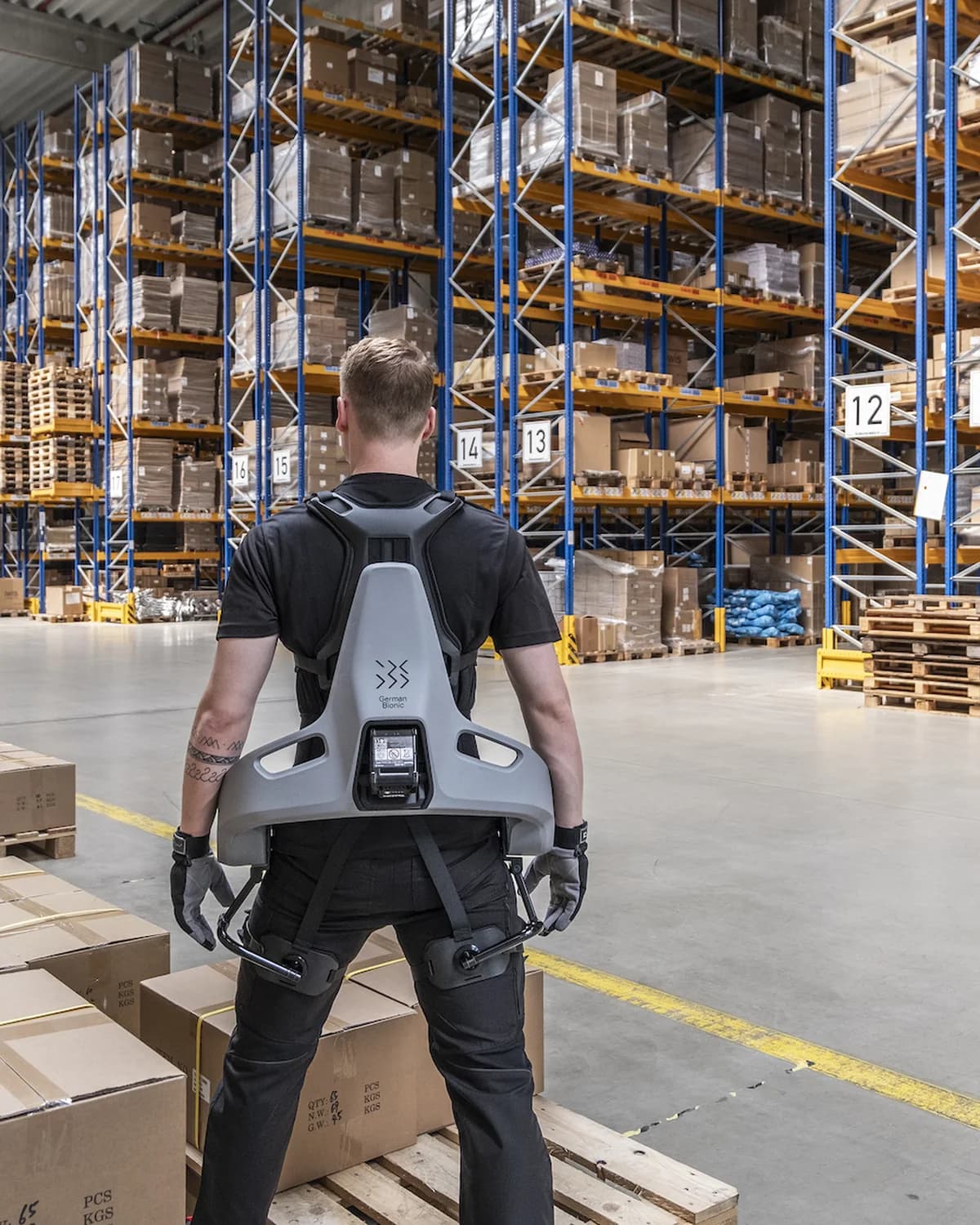A worker wearing the Cray X powered back exoskeleton in a warehouse.