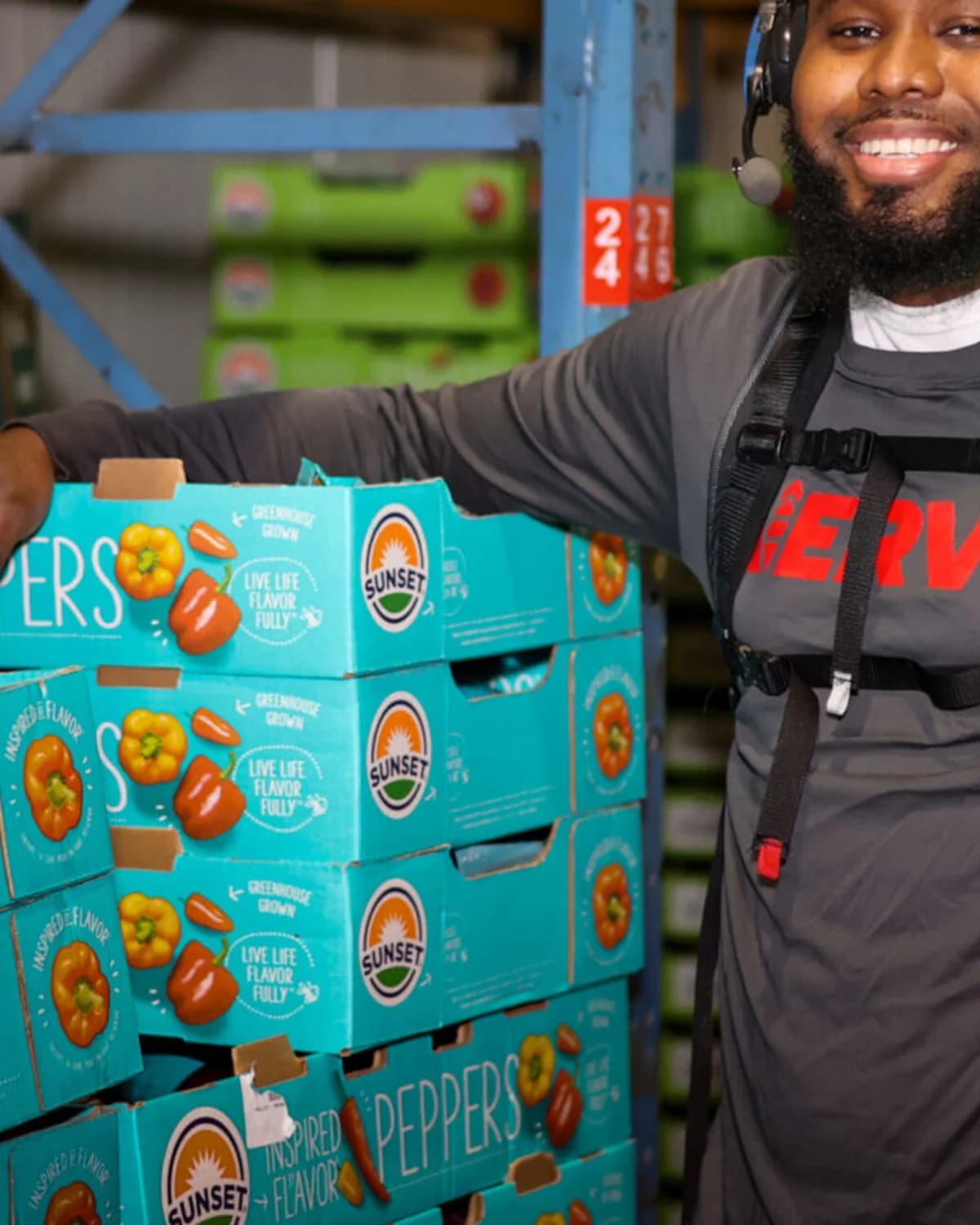 A worker wearing the Verve SafeBoost back exoskeleton while handling boxes.